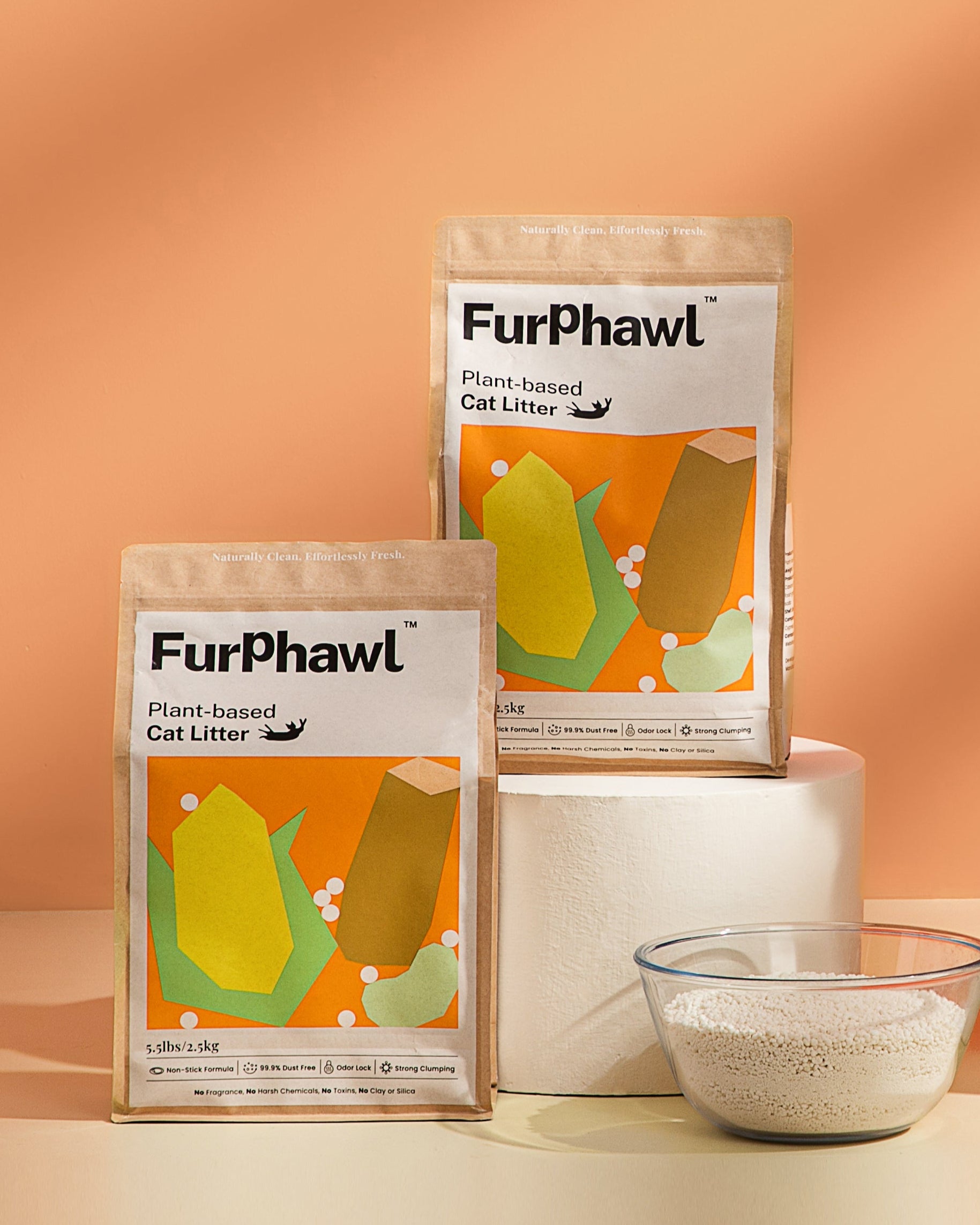 Cat sitting on a pedestal with FurPhawl Plant-based cat litter packaging on a peach background